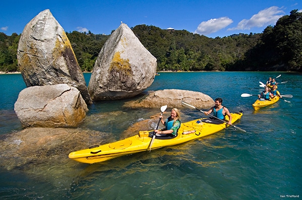 Kayakers on a lake with giant boulders