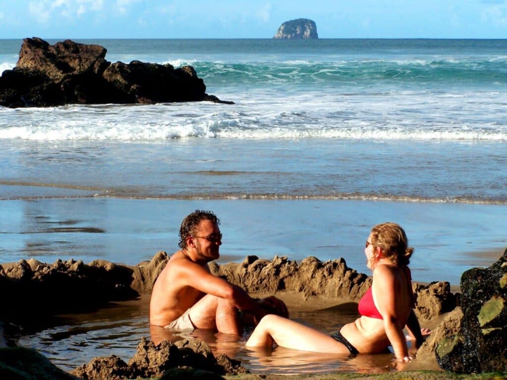 Couple soaking in a pool at Hot Water Beach, Coromandel