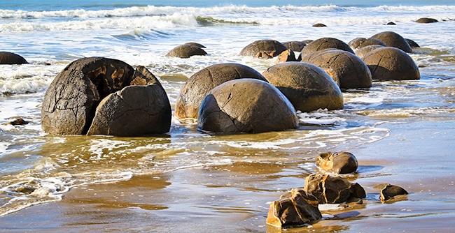 Spherical boulders in the surf, Moeraki Beach New Zealand