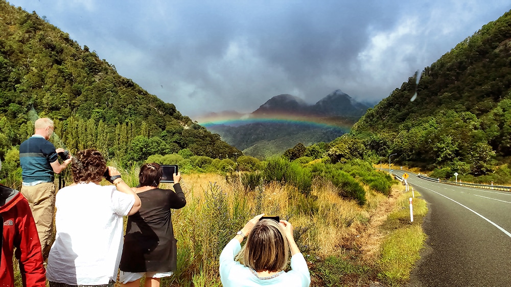 Rainbow on the road in the Southern Alps - Driving in New Zealand for Tourists