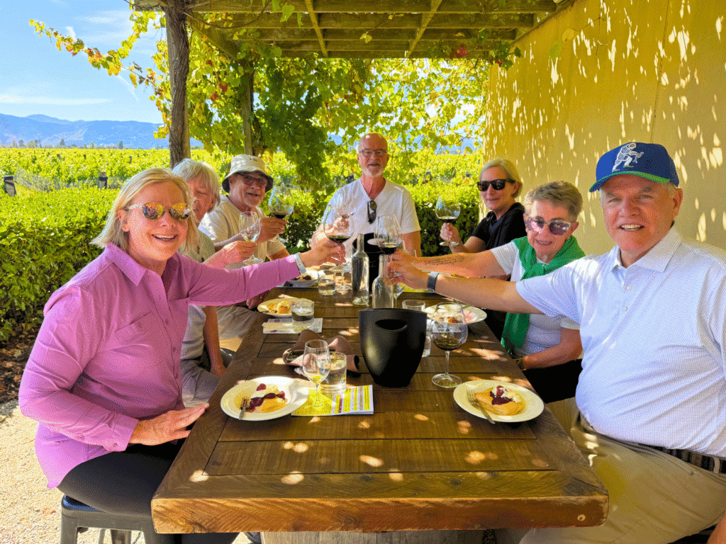 Travellers enjoying lunch in the sunshine at a winery in Marlborough, New Zealand.