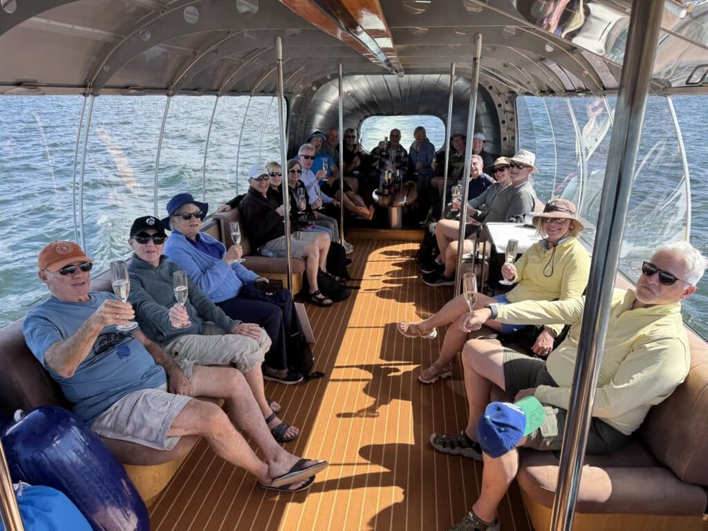 Travellers enjoying a drink on a small boat cruise on Lake Rotoiti in New Zealand