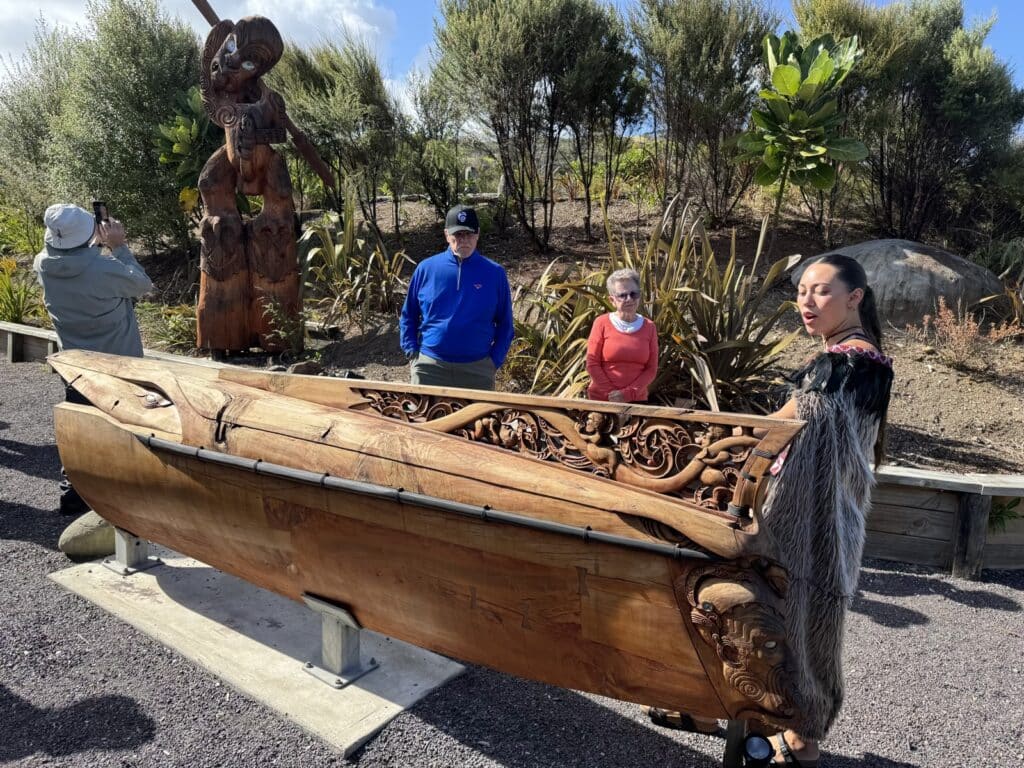 Maori guide and traditional carvings on a tour in the Hokianga in New Zealand