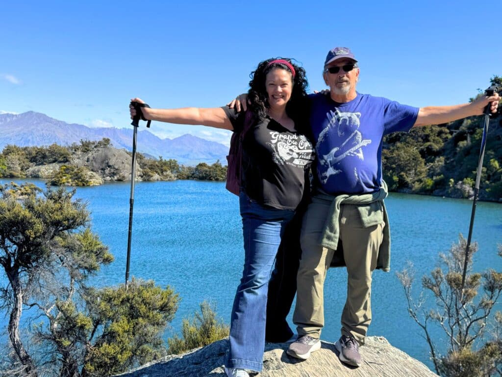 A couple in their 50s at the lookout over Lake Wanaka on Mou Waho Island, New Zealand