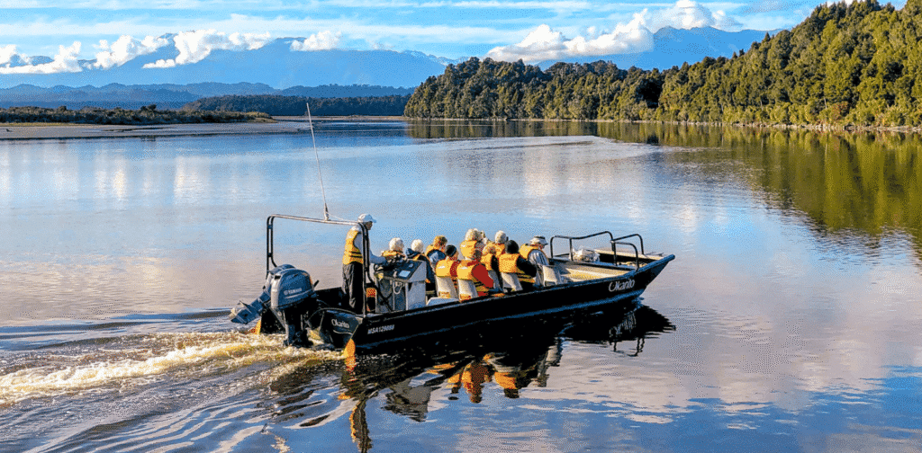 Travellers on a small boat nature cruise on Okarito Lagoon on the West Coast in New Zealand
