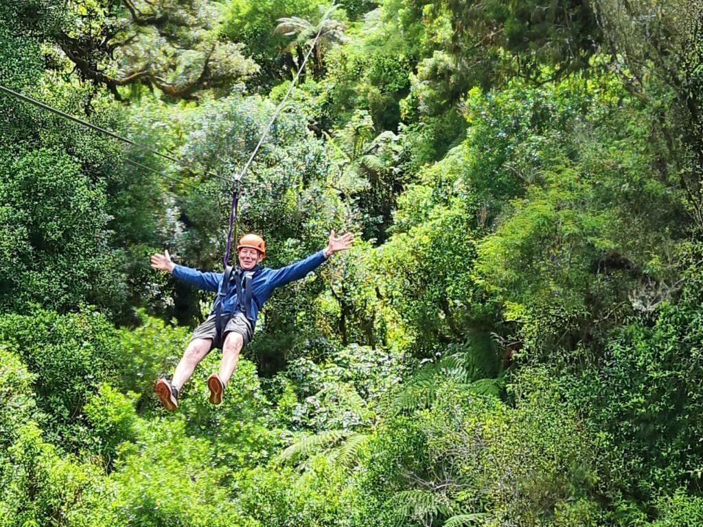 Senior traveller on a zip line above the forest in Rotorua, New Zealand