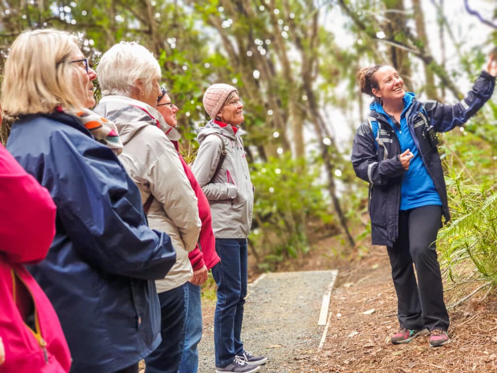 Guide and travellers on a tour on Ulva Island, Rakiura National Park, New Zealand