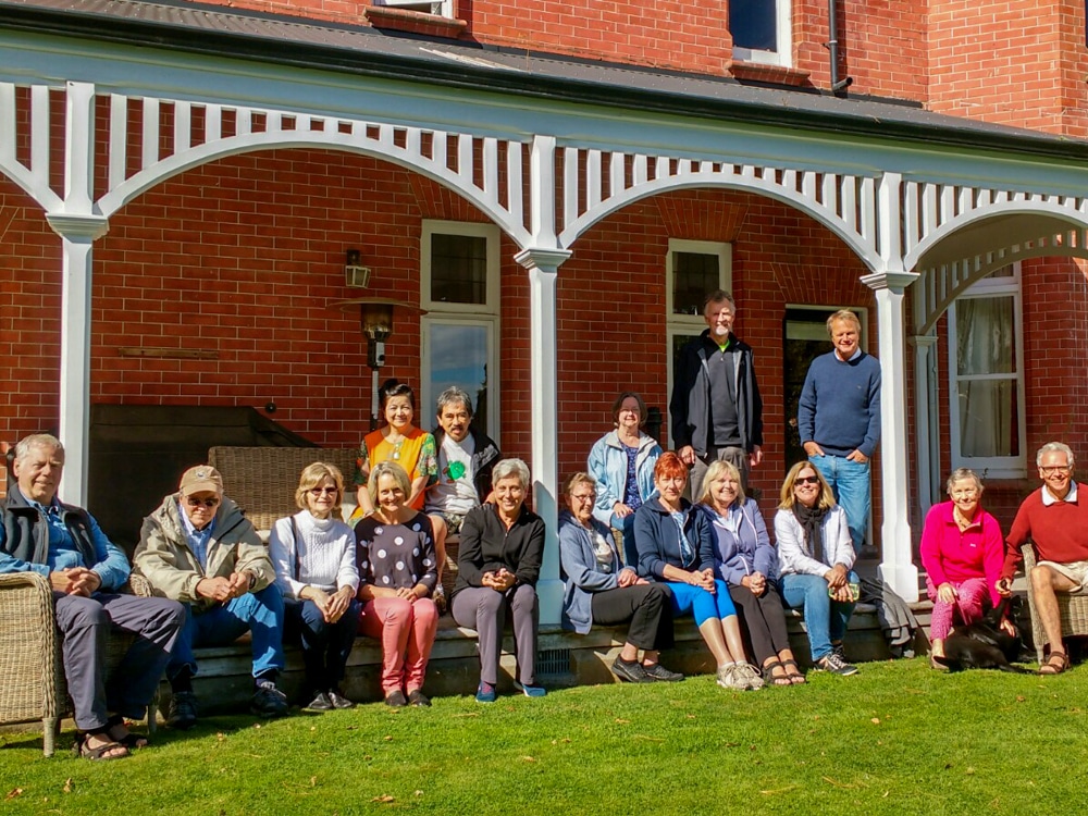 A small group tour on the porch at Akaunui homestead, with hosts Ian and Diana