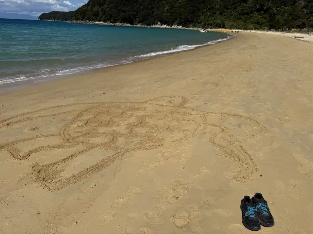 A Kiwi shape in the sand on the beach at Abel Tasman, New Zealand