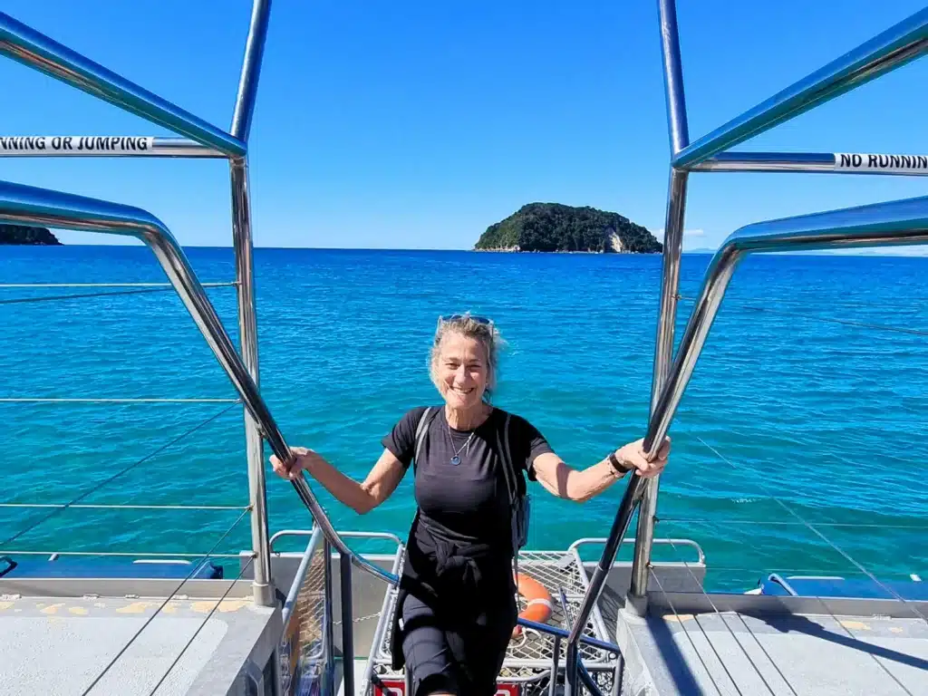 A senior traveller climbing the steps to the deck on an Abel Tasman Cruise, New Zealand
