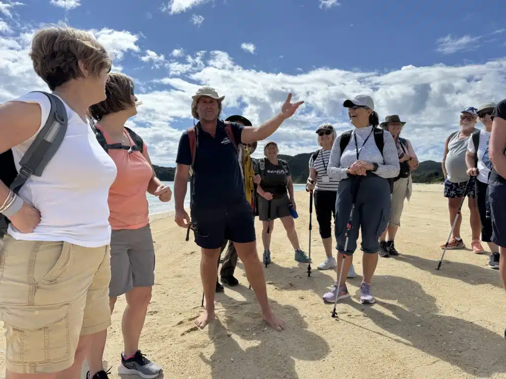 Group of senior travellers on the beach with a guide in Abel Tasman National Park