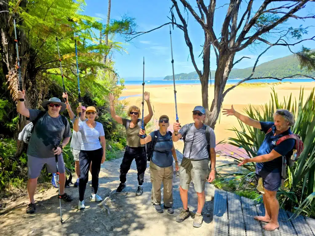 A group of senior travellers with a guide near the beach in Abel Tasman, New Zealand