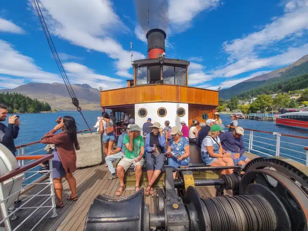 A group of over-50 travellers on the deck of the steamship TSS Earnslaw on Lake Wakatipu, Queenstown