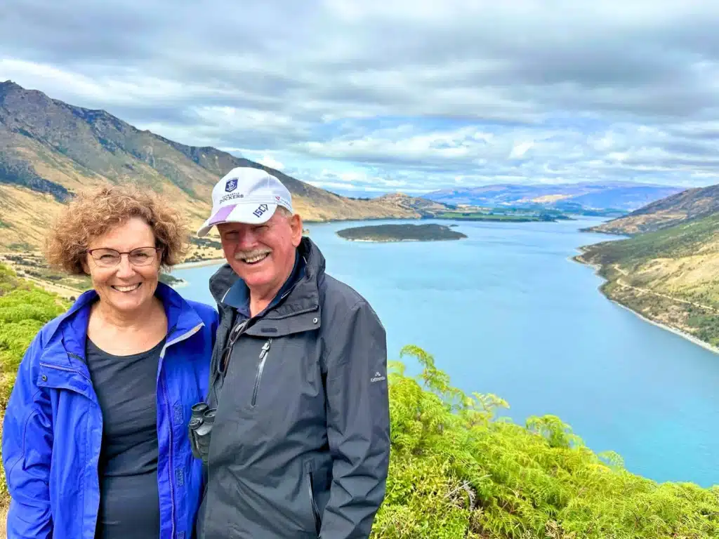 A couple in their 60s at the Glenorchy road lookout near Queenstown, New Zealand